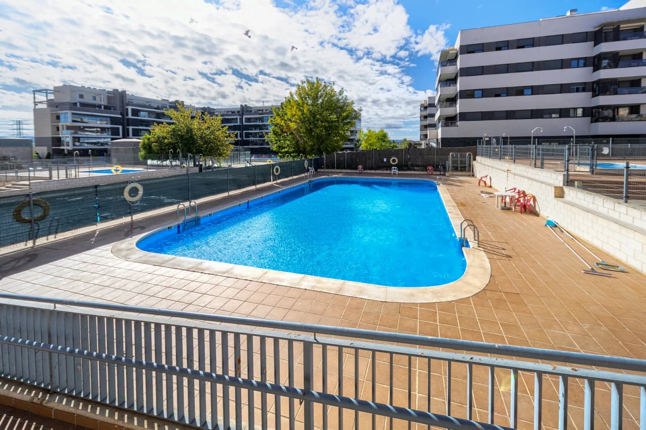 Piscina y solárium de la urbanización, con la segunda piscina al fondo