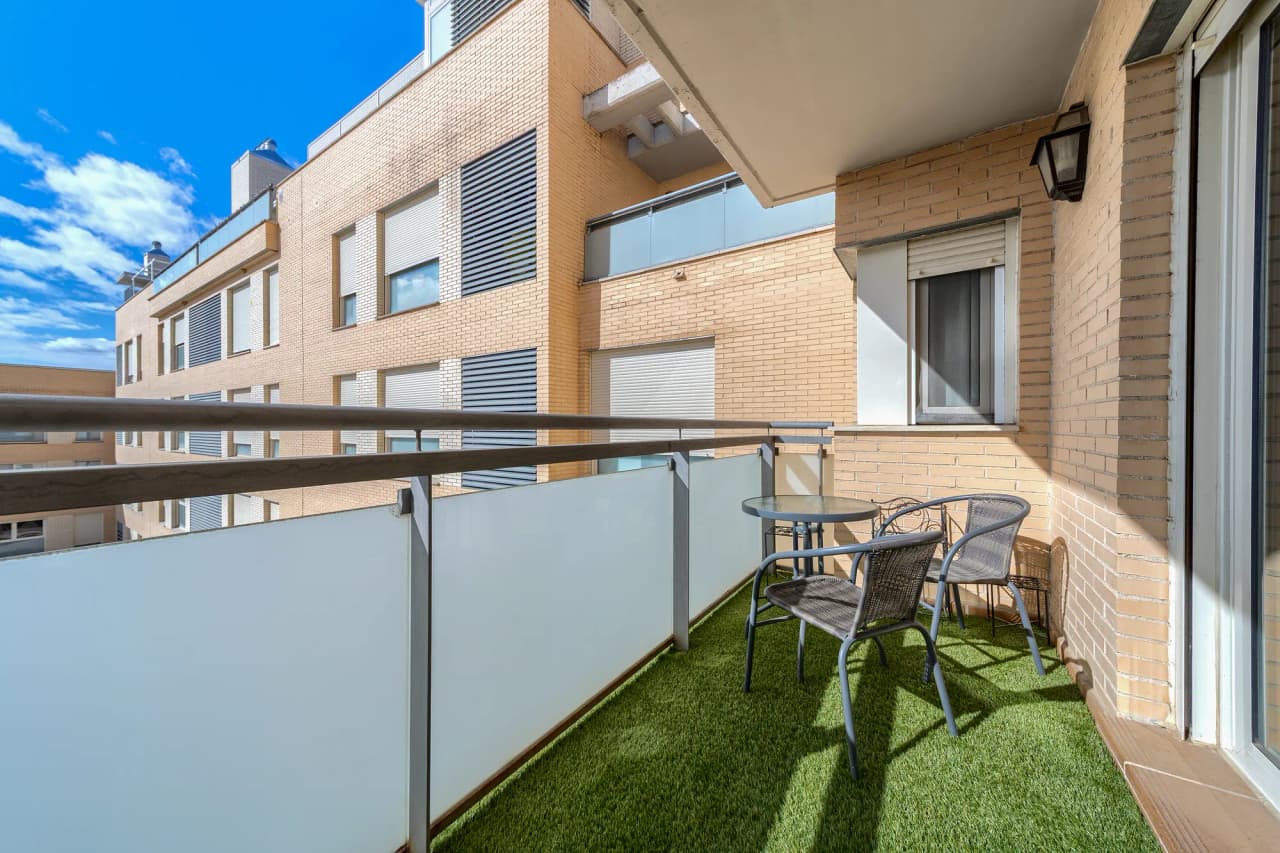 Terraza descubierta de uso privativo, con césped artificial, mesa y sillas