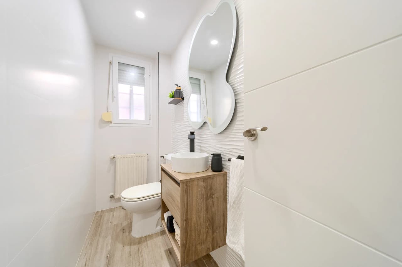 Aseo de la planta baja con lavabo sobre mueble de madera