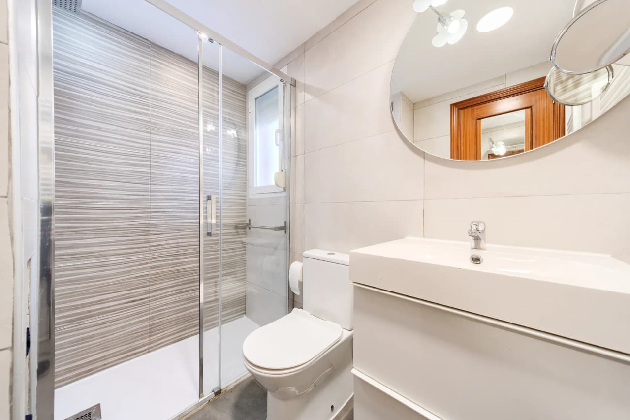 Baño completo con plato de ducha, mampara y mueble de lavabo