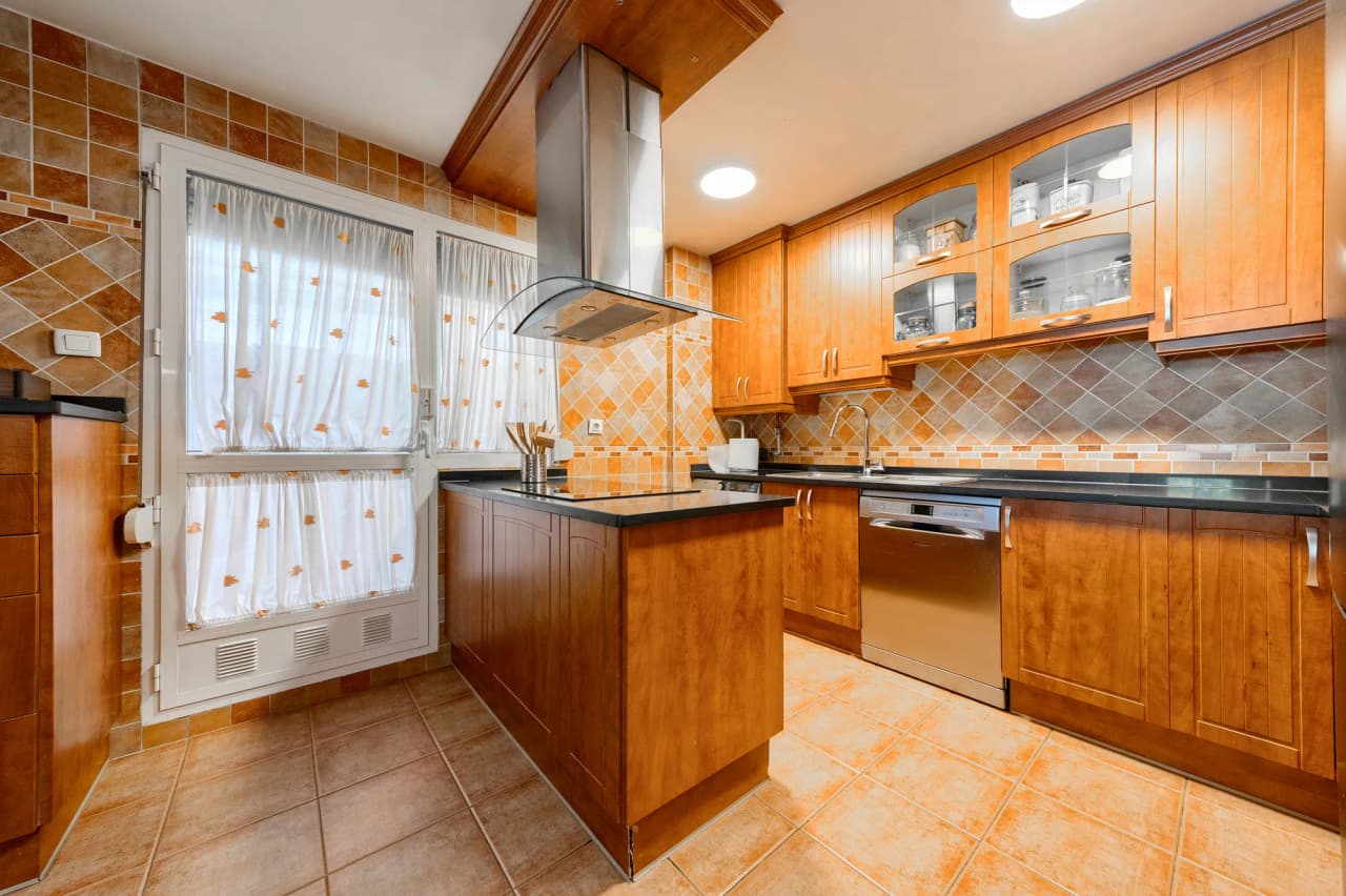 Cocina con isla, placa de inducción, campana y lavavajillas