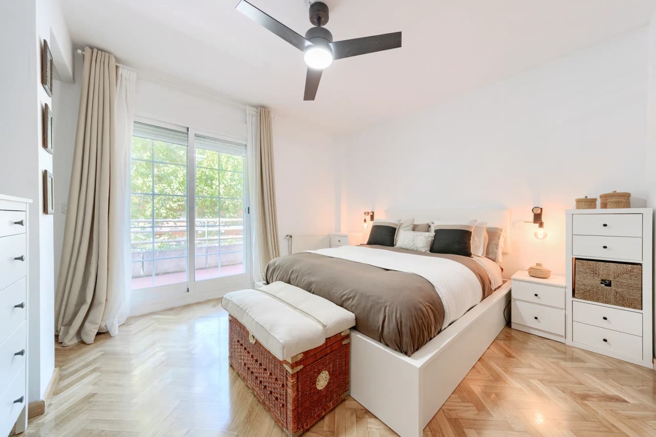 Dormitorio principal con cama de matrimonio y puerta corredera al exterior