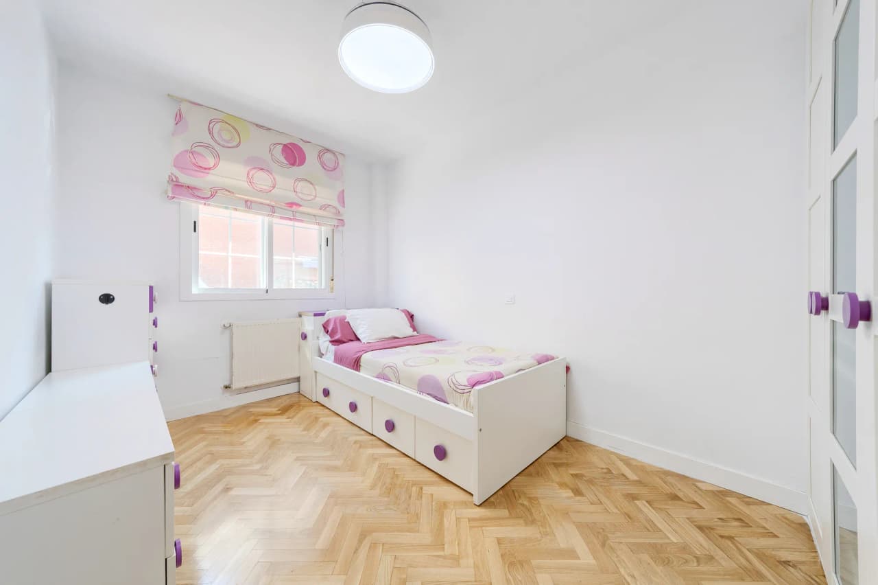 Segundo dormitorio con cama, armario empotrado y ventana