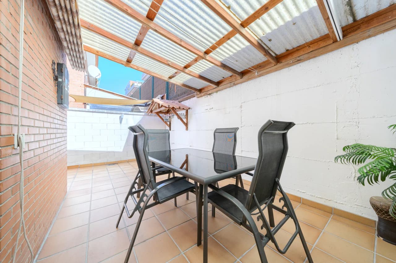Patio cubierto con pérgola y mesa para comer fuera