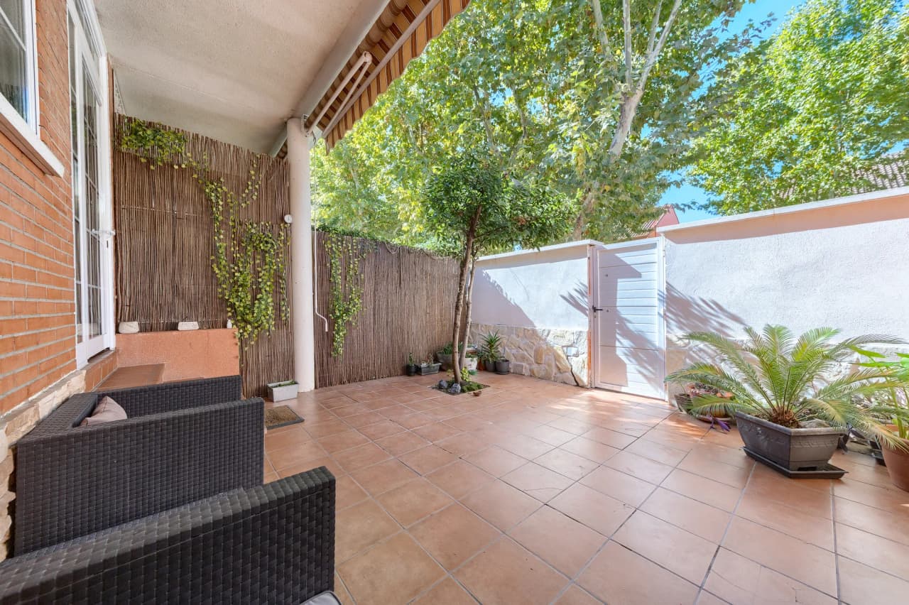 Patio trasero con toldo, plantas y puerta exterior