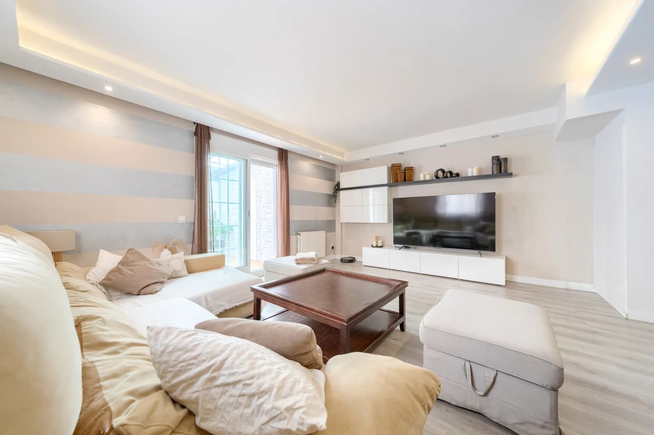 Salón visto desde el sofá, con el mueble de televisión y la salida al patio