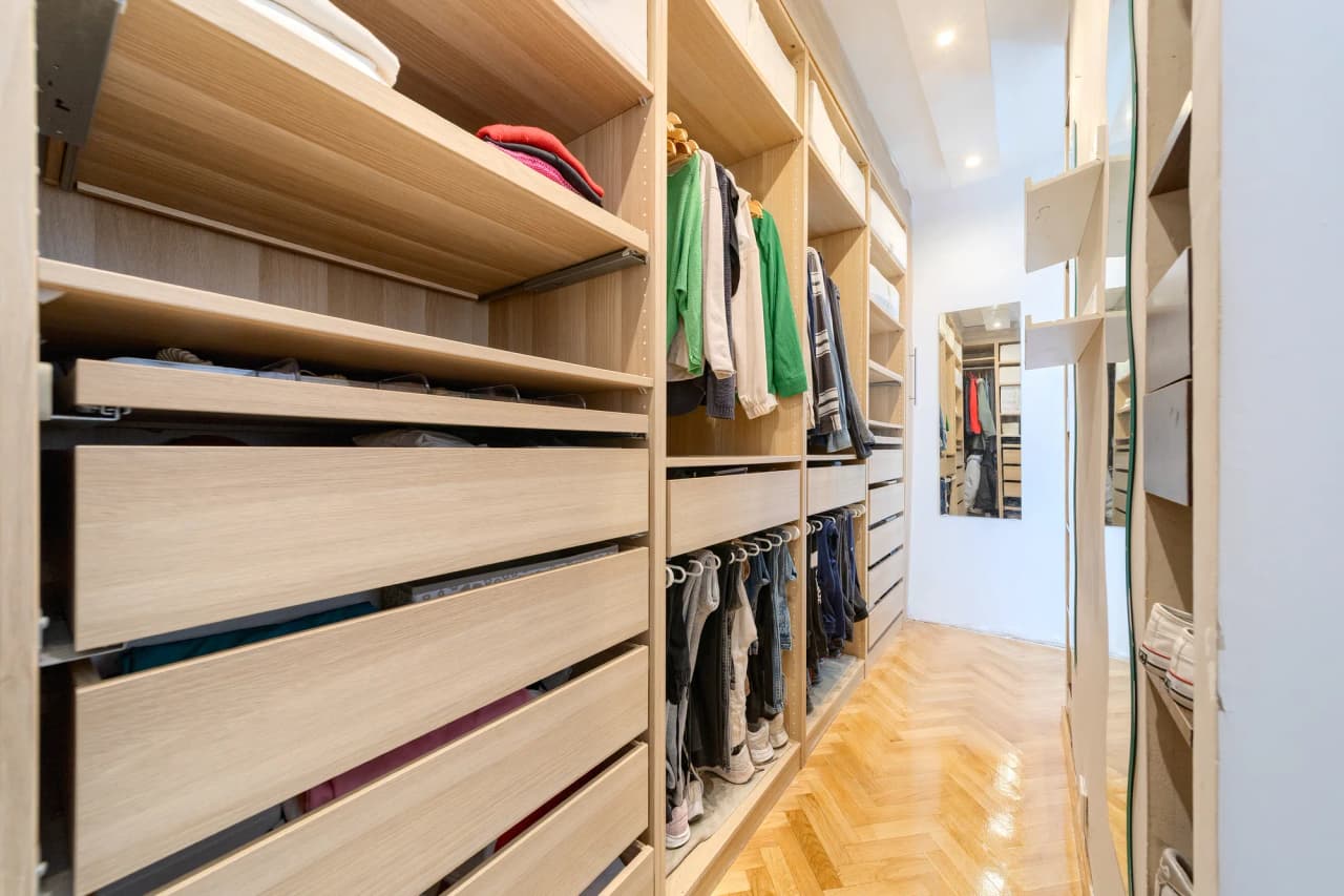 Vestidor de paso del dormitorio principal, con baldas, cajones y barras